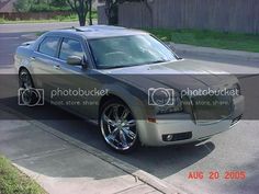 a silver car is parked on the side of the road in front of a house