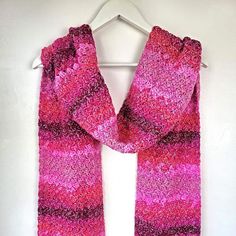 a pink scarf hanging on a white wall