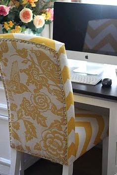 a yellow chair sitting in front of a computer desk