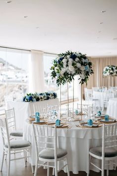 a table set up with white and blue flowers