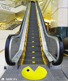 an escalator with yellow steps leading up to the top