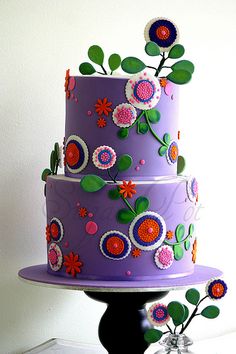 a three tiered cake decorated with flowers and leaves