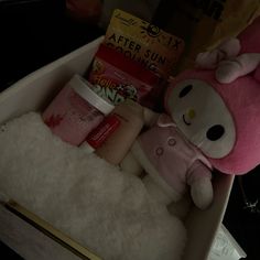 a hello kitty stuffed animal in a box with other items on it's side