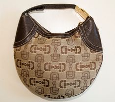 A Gucci mini hobo handbag.  The bag is made of brown and beige canvas with a horse-bit pattern, and it features brown leather trim and gold-tone hardware.  The interior is lined with brown fabric and next to the major compartment, it has one side pocket with a zipper. The bag has hardly any signs of use and it is in very good vintage condition. It will be delivered without a dust bag and cards. Measurements (cm & inch) Height: 19 cm / 7.5 inches Width (bottom): 12 cm / 4.75 inches Width (middle) Brown Shoulder Bag With Horsebit Detail, Brown Horsebit Shoulder Bag, Brown Bags With Horsebit Detail For Everyday Use, Monogram Canvas Shoulder Bag With Metal Hardware, Everyday Monogram Canvas Shoulder Bag With Metal Hardware, Brown Travel Bags With Horsebit Detail, Everyday Monogram Canvas Bag With Metal Hardware, Brown Satchel Shoulder Bag With Horsebit Detail, Beige Shoulder Bag With Horsebit Detail