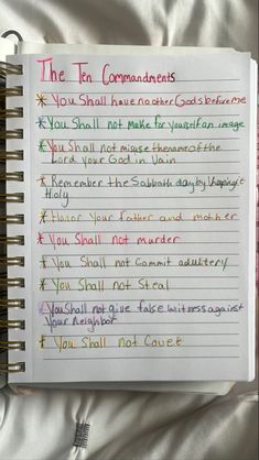 the ten commandments written on a notepad with colored pencils in front of it