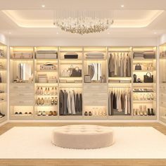 a walk in closet with chandelier, shoes and handbags on the shelves