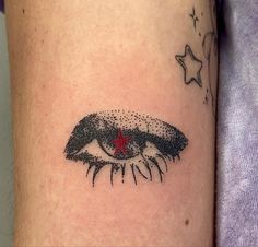 a close up of a person's arm with an eye and stars on it