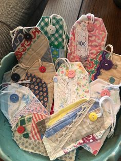 a bowl filled with lots of different types of fabric and buttons on top of a wooden table