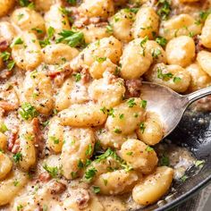 a skillet filled with pasta covered in cheese and parsley on top of it