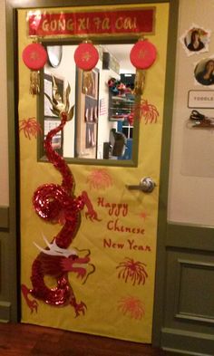 a chinese new year's door decorated with red and gold decorations, paper lanterns and a dragon