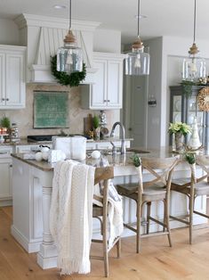 the kitchen is decorated in white and has lots of counter space for dining or entertaining