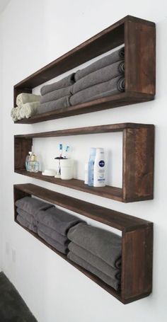 two wooden shelves holding towels and other bathroom items