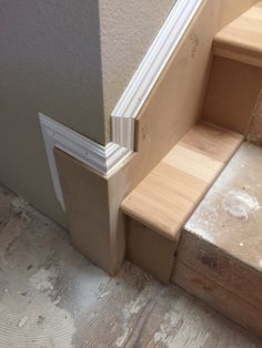 the bottom part of a stair case is being built into the wall by handrails