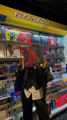 a man is holding up a sign in front of a book store filled with books