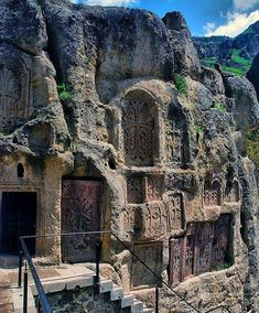 the stairs lead up to an ancient rock - hewn structure with carvings on it