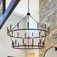 a large chandelier hanging from the ceiling in a room with stone walls and exposed beams