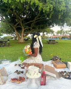 a woman sitting in front of a cake on top of a table