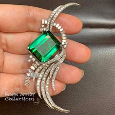 One of our favorite pieces in our collection, a stunning large green tourmaline is set in platinum and an elegant wispy arrangement of diamonds flows around!  Total Weight: 23 grams Size: 3 inch x 1 inch Precious Metal: Platinum Precious stones: -Green tourmaline: 19.1mmx15.8mm, 41 carats -White Round Diamonds: 5.5 carats Hallmark: Plat Elegant Green Diamond Brooch, Luxury Green Brooch For Formal Occasions, Luxury Green Brooches For Anniversary, Luxury Green Brooch For Anniversary, Elegant Green Gemstone Brooches, Elegant Green Gemstone Brooch, Luxury Green Brooches For Wedding, Elegant Green Brooches For Formal Occasions, Feather Brooch