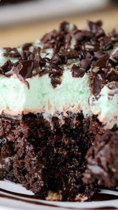 a piece of cake on a plate with chocolate chips and mint cream frosting in the middle