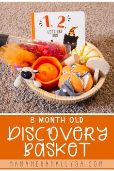 a basket filled with toys on top of a carpet next to a sign that says, 8 month old discovery basket