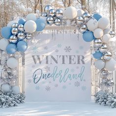 an arch decorated with balloons and snowflakes for a winter wonderland themed wedding ceremony