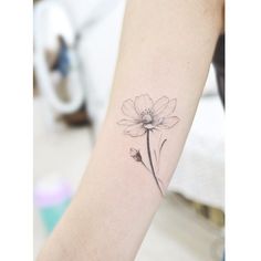 a small flower tattoo on the left inner forearm and lower arm, with an instagram message below it