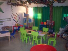 a child's playroom with green and yellow chairs, zebra stuffed animal hanging from the ceiling