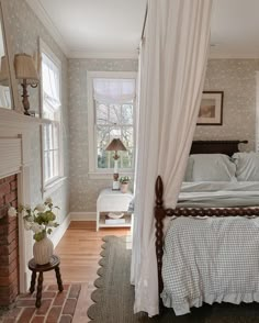 a bedroom with a bed, fireplace and window in the corner that has curtains over it