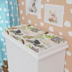 a baby's crib in the corner of a room with pictures on the wall