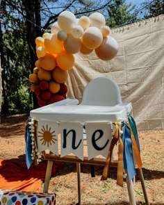 a baby's first birthday party with balloons and decorations, including a one high chair