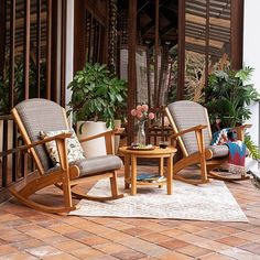 two wooden rocking chairs sitting on top of a patio next to a potted plant