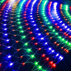 an array of multicolored lights are arranged on the floor in front of a building