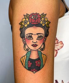 a woman's face with flowers on her head is shown in this tattoo design