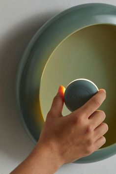 a person's hand is pressing the button on a bowl