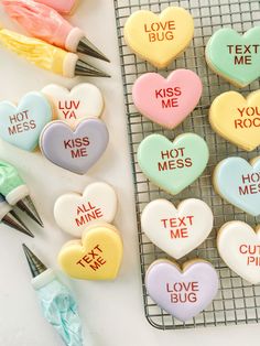 some cookies that are sitting on a cooling rack with pens and markers next to them