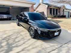 a black car parked in front of a garage