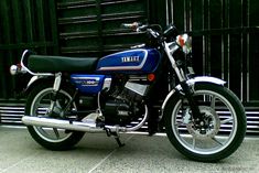 a blue and black motorcycle parked in front of a building