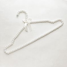 a white necklace with a bow and pearls