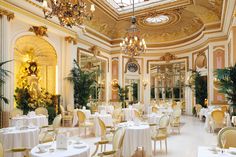 an ornately decorated dining room with chandeliers and white linens on tables