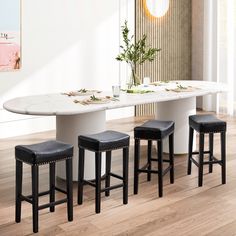 a dining table with four stools in front of it