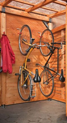 there is a bike hanging on the wall next to two hooks and a coat rack