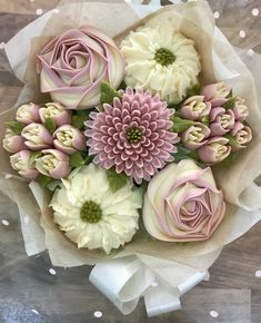 a bouquet of pink and white flowers sitting on top of a table