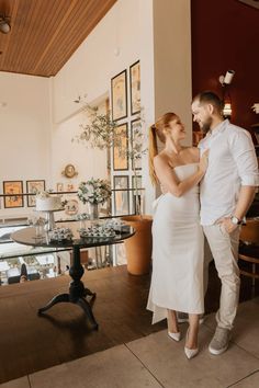 a man and woman standing next to each other in front of a dining room table