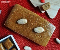 some food is laying out on a red place mat and next to it are two pieces of bread