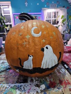 a carved pumpkin with ghost cats on it