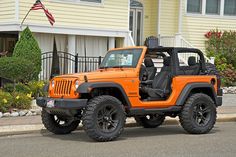 an orange jeep parked in front of a house