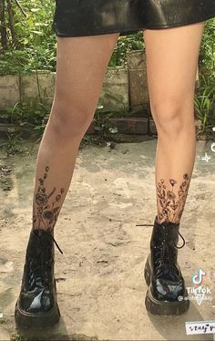 the legs and ankles of a woman with tattoos on her leg, wearing black shorts