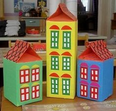 three cardboard houses sitting on top of a table