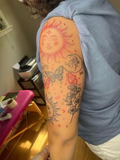 a man with a sun and flowers tattoo on his arm