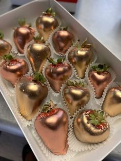 chocolate covered strawberries in a white box with gold foiled strawberry decorations on top